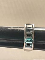 Frontal view of ring showing four aquamarine stones in channel setting