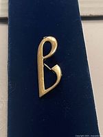 Front view of gold-tone letter b brooch