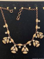 Full view of gold-tone necklace on display board