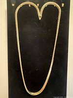 Full view of gold-plated rope chain necklace hanging