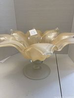 Front angled view of the decorative glass vase with ruffled petals and pedestal base.