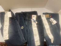 Three pairs of Gsus Original denim jeans displayed side by side showing brand tags and branding bands.
