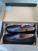 Pair of black UMI Metro SAUL II loafer shoes inside their original box, showing shoe shape and condition.