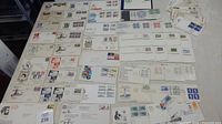 Overview of majority of the 88 first day covers laid out on table