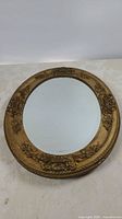 Full view of oval mirror showing frame design and glass
