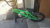 Left side view of green Radio Bike Co BMX bicycle showing frame, wheels and missing brake setup