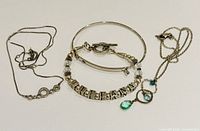 Full view of all five jewelry pieces: two necklaces, two bangles, one bracelet