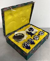 Original presentation box with yellow satin inside lining holding the tea set securely.