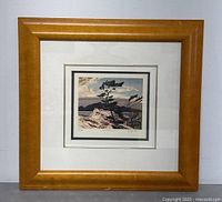 Full front view showing light wood frame, white mat and artwork under glass