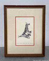 Full front view of the framed black and white Indigenous style print featuring a kneeling raven figure.