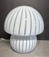 Front view of the white opaline glass mushroom lamp showing overall shape and ribbed stripe pattern