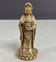 Front view of the bronze Guanyin statue showing detailed facial features, robes, jewelry, and lotus base.