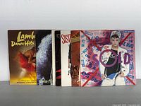 Photo showing six LP vinyl record covers stacked and facing front showing artist and album art