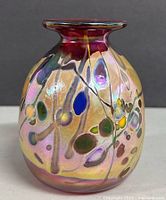 Front view of the signed Rick Hunter iridescent art glass vase with colorful abstract patterns.