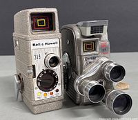Front view of Keystone K-27 Capri 8mm turret film camera and Bell & Howell 319 movie camera showing lenses and viewfinders