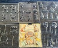 Group shot of five loose clear plastic molds and one sealed Precious Moments mold