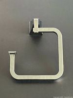 Front view of chrome towel hanger on dark background