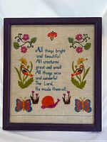 Front view of framed embroidered sampler with verse and colourful motifs
