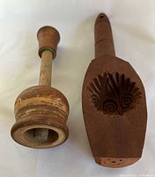 Both wooden butter molds side by side showing shapes and carved details