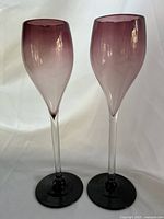 Front view of both wine glasses showing purple ombre bowls and dark bases