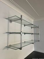 overall view of glass shelves assembled on wall showing three tiers and pipe brackets