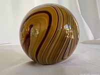 Full view of the glass paperweight showing swirl pattern