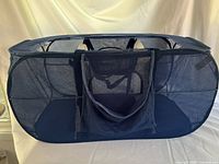 Full view of navy blue mesh hamper folded open