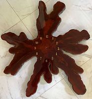 Front view of lacquered live-edge cypress clock face with gold numbers visible