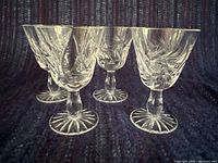 Four cut-crystal liqueur glasses angled side view