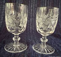 Front view of both matching cut crystal liqueur glasses displaying bowl pattern, stems and bases