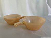 Two peach lustre Fire King beehive handled bowls, side view