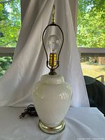Full view of cream glass lamp showing body, base and cord