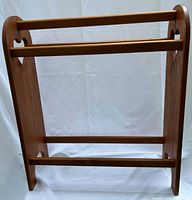 Front view of wooden quilt rack showing three bars and heart cutouts