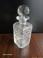 Full view of decanter standing upright showing stopper and cut design