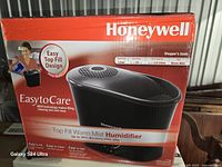 Front of sealed retail box showing Honeywell Easy to Care Top Fill Warm Mist Humidifier