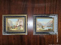 Both framed paintings side by side on wall