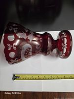 Vase lying sideways with tape measure indicating length