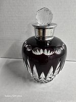 Front view showing ruby red cut crystal bottle with stopper