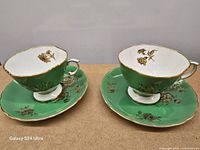 Two teacups on matching saucers showing pattern and color
