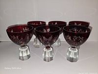 Front view of six ruby red cut to clear crystal liquor glasses