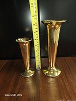 Both gold glazed porcelain vases with tape for scale