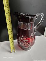 Full view of jug next to tape measure showing height ~8 in