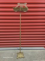 Full view of brass music stand extended showing base and lyre top