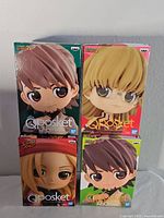 Front view of four sealed Qposket figure boxes