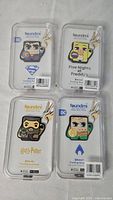 Front view of four sealed Foundmi tracking keychains displaying character designs and branding