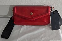 Front view of red patent crossbody purse with flap and snap
