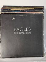 Front cover of Eagles The Long Run atop record stack