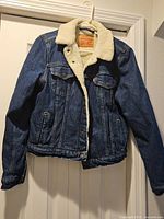 Front view of Levi's sherpa denim jacket hanging