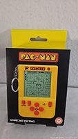 Front of boxed Pac-Man LCD handheld game keyring showing screen, buttons, keyring attachment