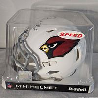 Front-left view of boxed signed mini helmet showing team logo and packaging